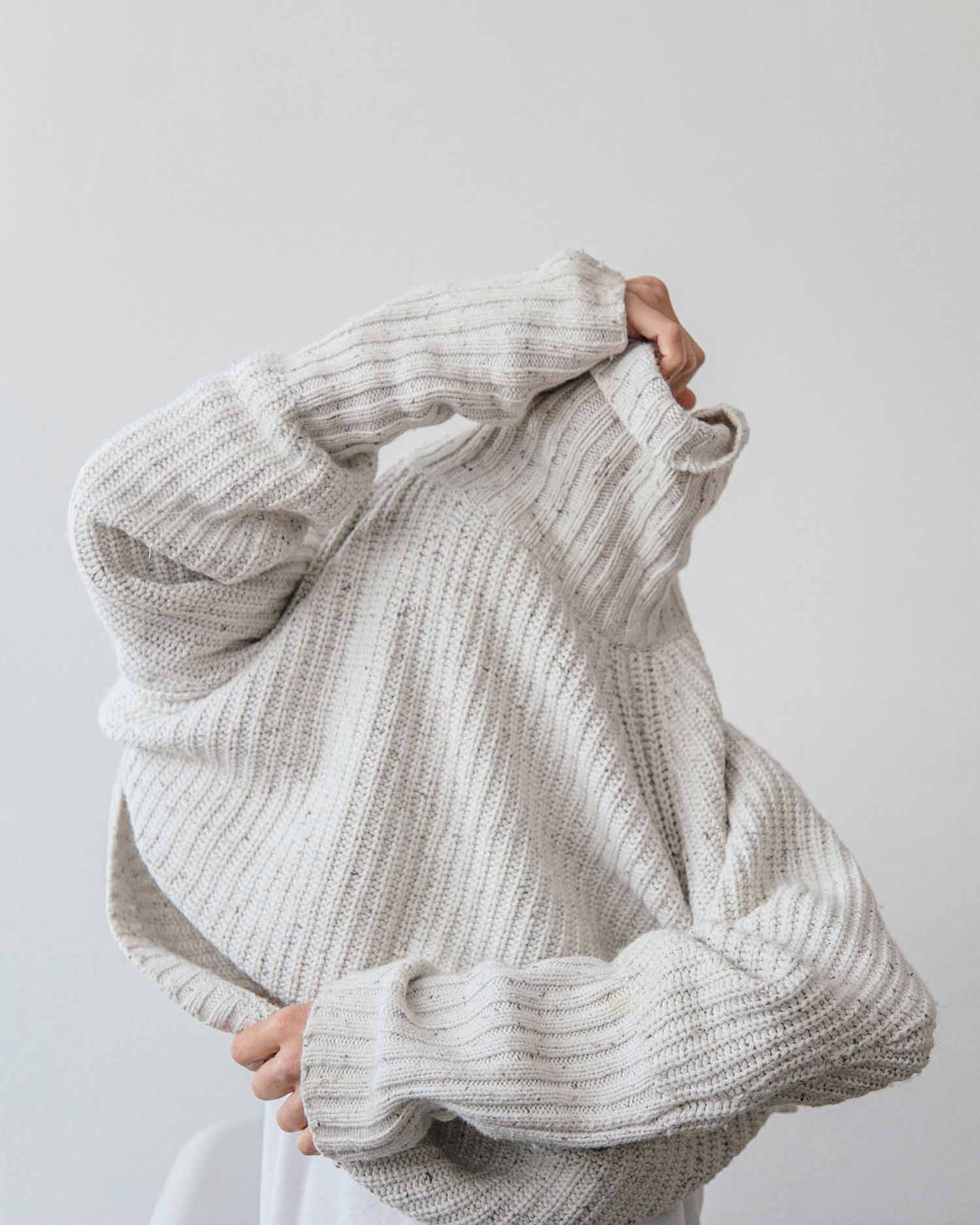 a person holding up a sweater